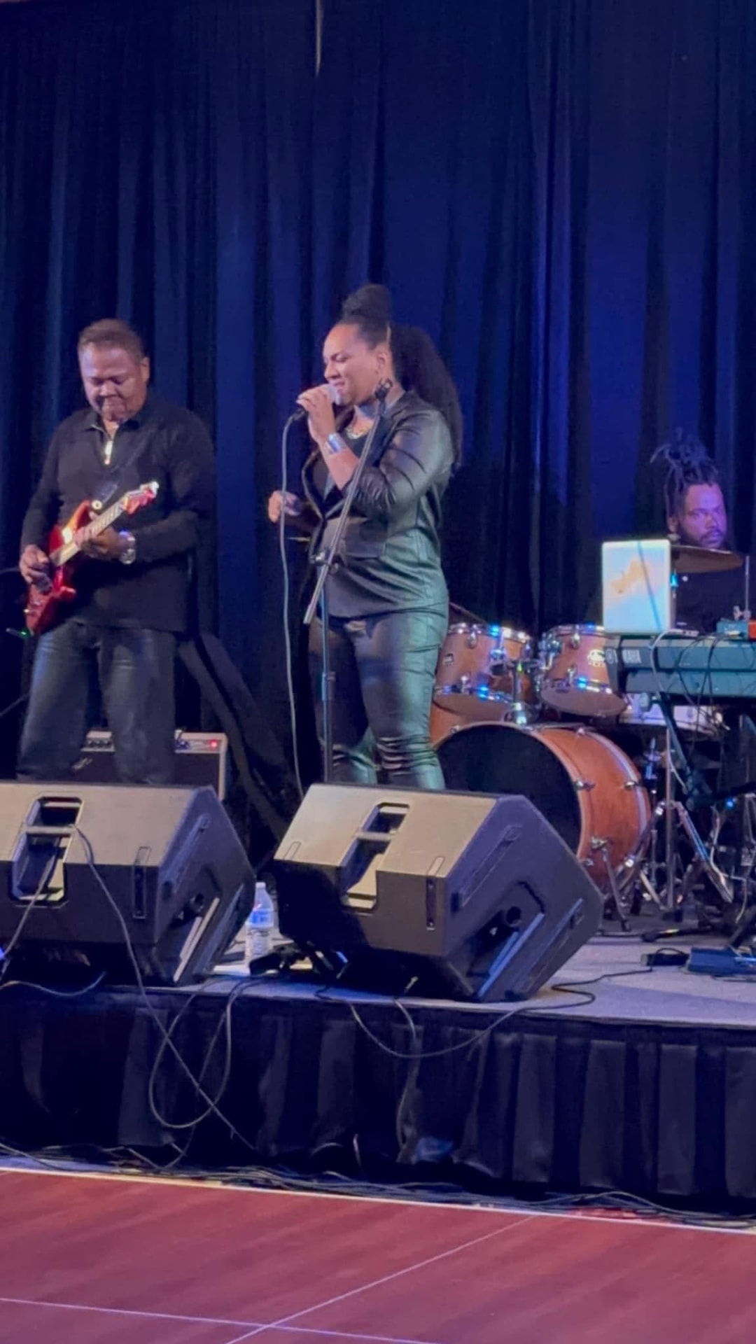 Christina Cunningham on a main stage with a guitarist and drummer behind her