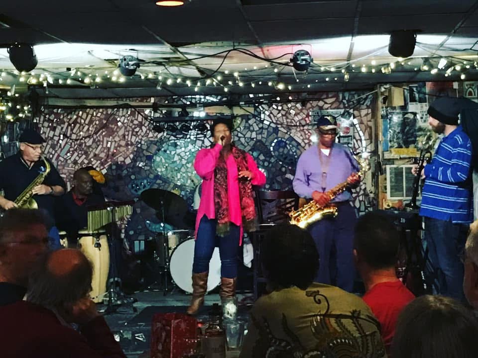 Christina Cunningham performing with two saxophonists in a club